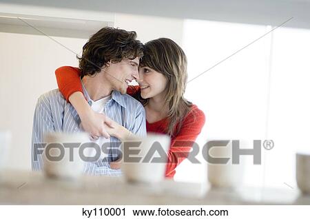 Young couple embracing, looking at each other View Large Photo Image Stock Image - Young couple embracing, looking at each other. Fotosearch