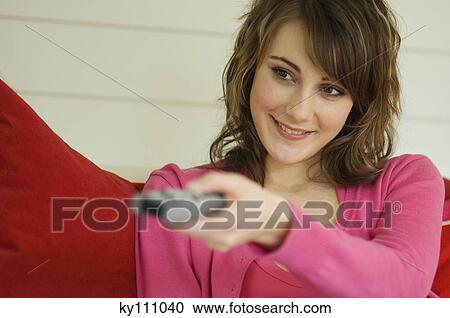 Portrait of a woman using remote-control View Large Photo Image Stock Image - Portrait of a woman using remote-control. Fotosearch
