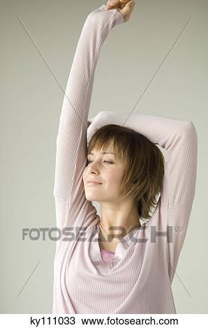 Portrait of a young woman stretching View Large Photo Image Stock Image - Portrait of a young woman stretching. Fotosearch