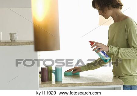 Young woman cleaning kitchen work-top View Large Photo Image Stock Photo - Young woman cleaning kitchen work-top. Fotosearch