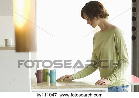 Young woman cleaning kitchen work-top View Large Photo Image Stock Photo - Young woman cleaning kitchen work-top. Fotosearch