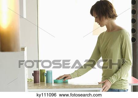 Young woman cleaning kitchen work-top View Large Photo Image Stock Photograph - Young woman cleaning kitchen work-top. Fotosearch