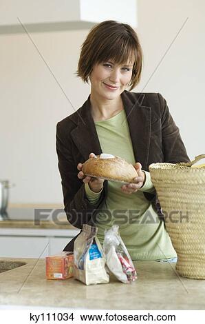 Young woman emptying shopping basket in the kitchen View Large Photo Image Picture - Young woman emptying shopping basket in the kitchen. Fotosearch