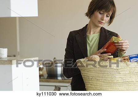 Young woman emptying shopping basket in the kitchen View Large Photo Image Stock Image - Young woman emptying shopping basket in the kitchen. Fotosearch