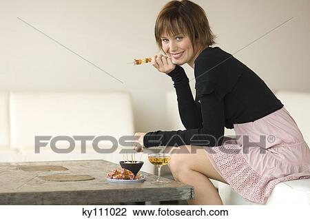 Young woman having aperitive in living-room, smiling for the camera View Large Photo Image Stock Image - Young woman having aperitive in living-room, smiling for the camera. Fotosearch