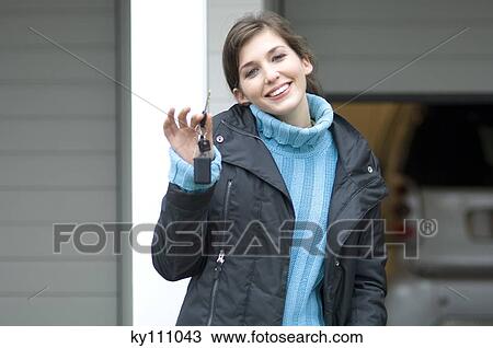 Young woman holding car keys outdoors, smiling for the camera View Large Photo Image Stock Image - Young woman holding car keys outdoors, smiling for the camera. Fotosearch