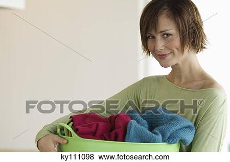Young woman holding clothes basket View Large Photo Image Stock Photo - Young woman holding clothes basket. Fotosearch