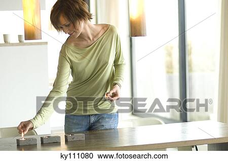 Young woman lighting candles View Large Photo Image Stock Image - Young woman lighting candles. Fotosearch