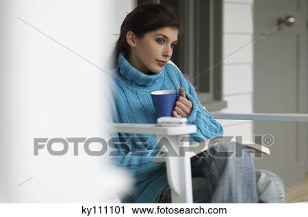 Young woman reading, sitting on a chair, outdoors View Large Photo Image Stock Image - Young woman reading, sitting on a chair, outdoors. Fotosearch