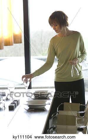 Young woman setting the table View Large Photo Image Picture - Young woman setting the table. Fotosearch