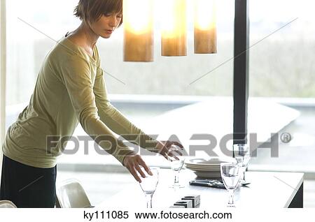 Young woman setting the table View Large Photo Image Stock Photography - Young woman setting the table. Fotosearch