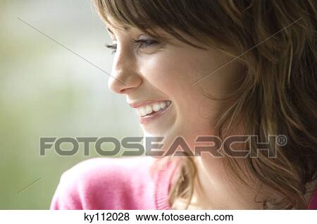 Stock Photo - Portrait of a young smiling woman, in profile. Fotosearch