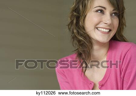 Stock Photograph - Portrait of a young smiling woman looking away. Fotosearch