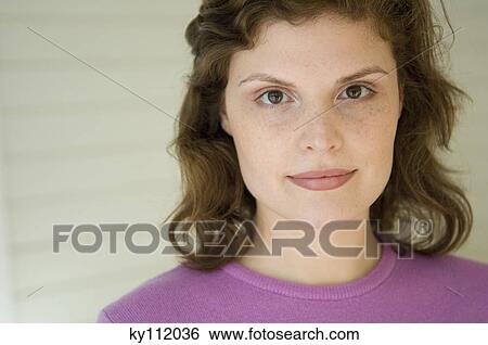 Stock Photograph - Portrait of a young woman looking at the camera. Fotosearch
