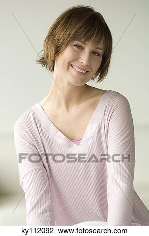 Stock Image - Portrait of a young woman smiling for the camera. Fotosearch