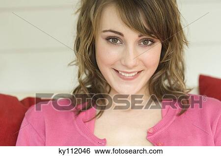 Stock Photograph - Portrait of a young woman smiling for the camera. Fotosearch