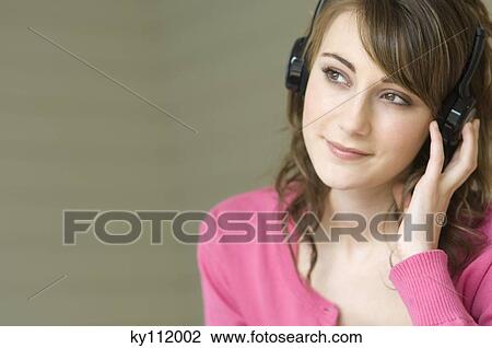 Portrait of a young woman wearing headphones View Large Photo Image Stock Image - Portrait of a young woman wearing headphones. Fotosearch