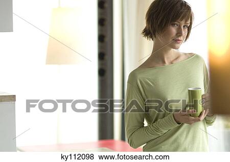 Stock Photo - Young thinking woman holding a cup. Fotosearch