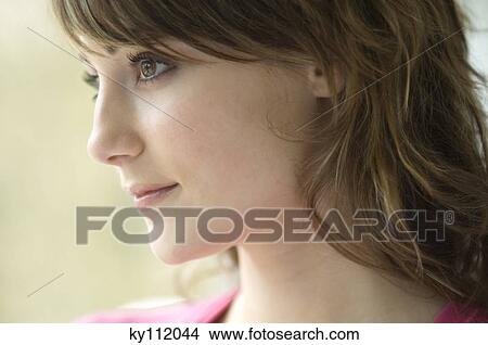 Picture - Young thinking woman, in profile, close-up. Fotosearch