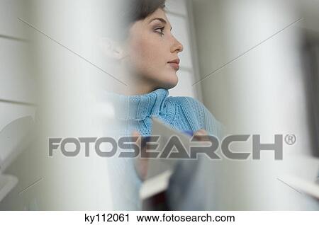Stock Image - Young woman reading a book. Fotosearch