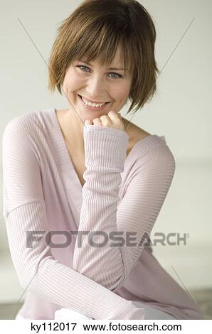 Young woman smiling for the camera View Large Photo Image Stock Photo - Young woman smiling for the camera. Fotosearch