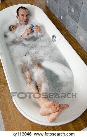 Man having a bath, looking at the camera, elevated view View Large Photo Image Stock Photograph - Man having a bath, looking at the camera, elevated view. Fotosearch