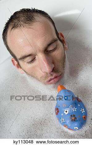 Man having a bath, playing with a plastic duck View Large Photo Image Stock Photo - Man having a bath, playing with a plastic duck. Fotosearch