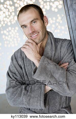 Man in grey bathrobe, leaning against wall, smiling for the camera View Large Photo Image Stock Photo - Man in grey bathrobe, leaning against wall, smiling for the camera. Fotosearch