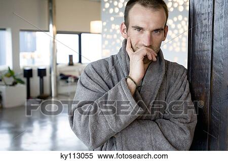 Man in grey bathrobe, leaning against wall, looking at the camera View Large Photo Image Stock Photography - Man in grey bathrobe, leaning against wall, looking at the camera. Fotosearch