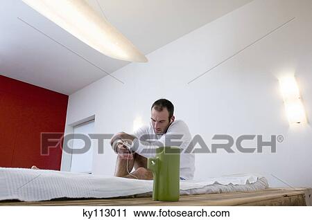 Man listening to iPod player, sitting on a bed View Large Photo Image Stock Image - Man listening to iPod player, sitting on a bed. Fotosearch