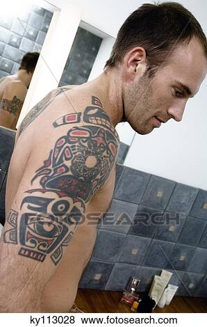 Tattooed man, barechested, standing in the bathroom, in profile View Large Photo Image Stock Photo - Tattooed man, barechested, standing in the bathroom, in profile. Fotosearch