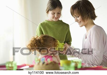 2 little girls giving present to smiling woman View Large Photo Image Stock Image - 2 little girls giving present to smiling woman. Fotosearch