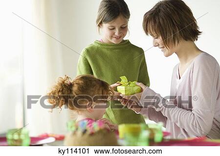 2 little girls giving present to smiling woman View Large Photo Image Stock Image - 2 little girls giving present to smiling woman. Fotosearch