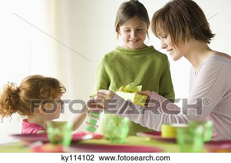 2 little girls giving present to smiling woman View Large Photo Image Stock Image - 2 little girls giving present to smiling woman. Fotosearch