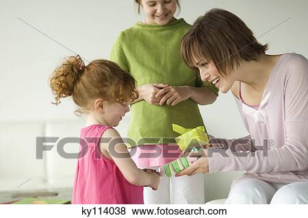 2 little girls giving presents to smiling woman View Large Photo Image Stock Photo - 2 little girls giving presents to smiling woman. Fotosearch