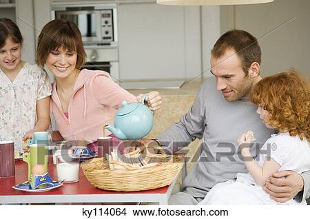 Couple and 2 little girls at breakfast table View Large Photo Image Picture - Couple and 2 little girls at breakfast table. Fotosearch