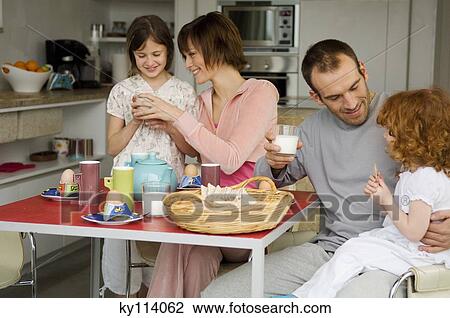 Couple and 2 little girls at breakfast table View Large Photo Image Stock Image - Couple and 2 little girls at breakfast table. Fotosearch