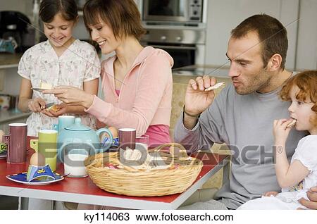 Couple and 2 little girls at breakfast table View Large Photo Image Stock Image - Couple and 2 little girls at breakfast table. Fotosearch