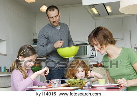 Couple and 2 little girls having lunch View Large Photo Image Stock Photograph - Couple and 2 little girls having lunch. Fotosearch