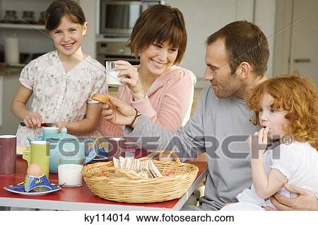 Picture - Couple and 2 little girls having breakfast. Fotosearch