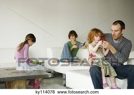 Couple and 2 little girls in the living-room View Large Photo Image Stock Photo - Couple and 2 little girls in the living-room. Fotosearch