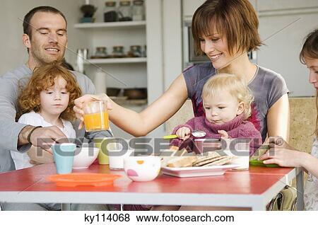 Couple and 3 children at breakfast table View Large Photo Image Stock Photo - Couple and 3 children at breakfast table. Fotosearch