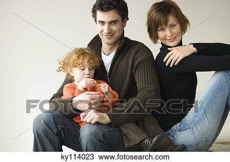 Couple and little girl sitting on the floor, looking at the camera View Large Photo Image Stock Image - Couple and little girl sitting on the floor, looking at the camera. Fotosearch