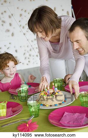 Couple and little girl with birthday cake at lunch table View Large Photo Image Stock Photography - Couple and little girl with birthday cake at lunch table. Fotosearch
