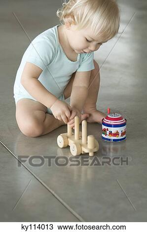 Stock Image - Little boy playing on the floor. Fotosearch