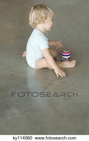 Little boy sitting on the floor, playing with music box View Large Photo Image Stock Image - Little boy sitting on the floor, playing with music box. Fotosearch