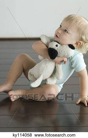Little boy sitting on the floor, holding stuffed dog View Large Photo Image Stock Photo - Little boy sitting on the floor, holding stuffed dog. Fotosearch