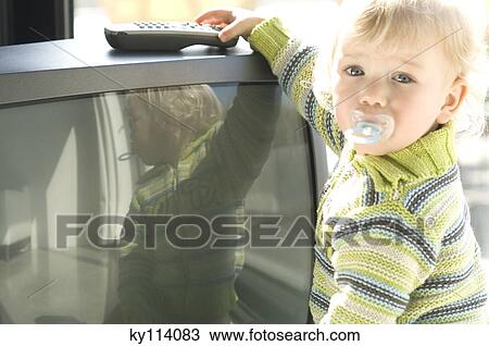 Little boy with pacifier taking TV remote control View Large Photo Image Stock Image - Little boy with pacifier taking TV remote control. Fotosearch