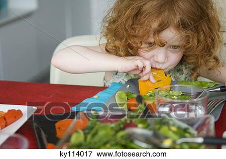 Little girl at lunch table, eating with hands View Large Photo Image Stock Photo - Little girl at lunch table, eating with hands. Fotosearch