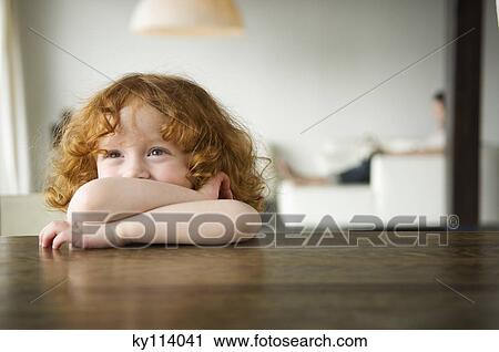 Little girl resting her arms on a coffee table View Large Photo Image Stock Image - Little girl resting her arms on a coffee table. Fotosearch